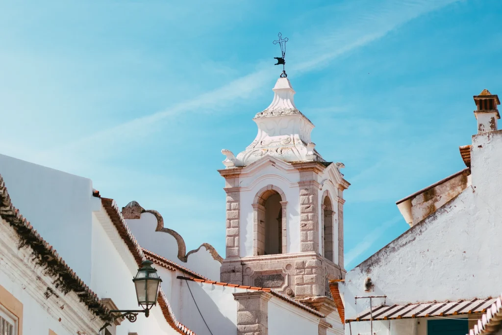 Church tower above whitewashed buildings in Lagos Old Town, Portugal