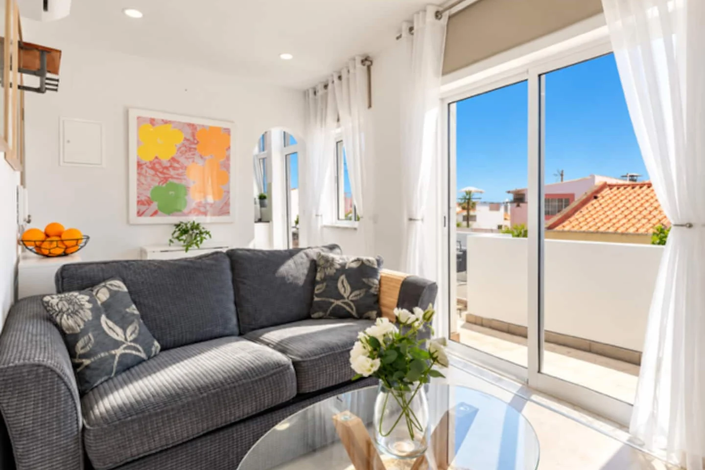 Grey sofa, glass coffee table and doors to the terrace at Old Town Terrace